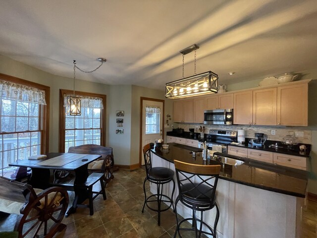314 Birdsong Dr, Cadiz, KY 42211 - kitchen featuring appliances with stainless steel finishes, a chandelier, dark countertops, tasteful backsplash, and decorative light fixtures