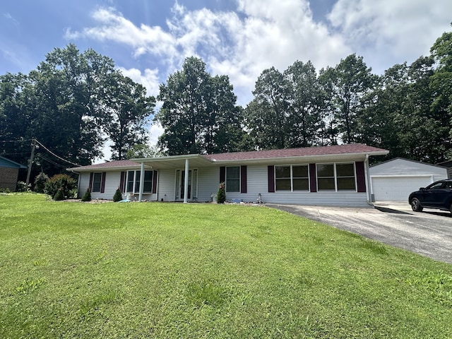 single story home with a front lawn, an outbuilding, a porch, and a garage