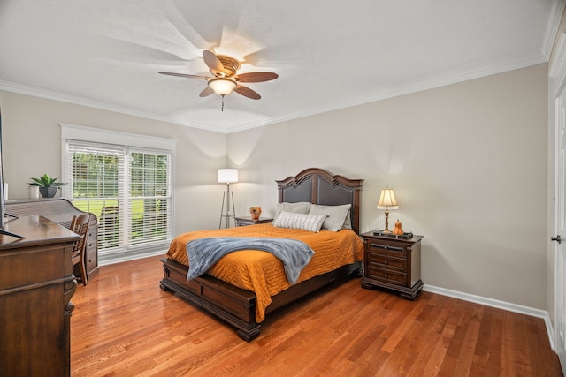 bedroom featuring hardwood / wood-style flooring, ceiling fan, and crown molding