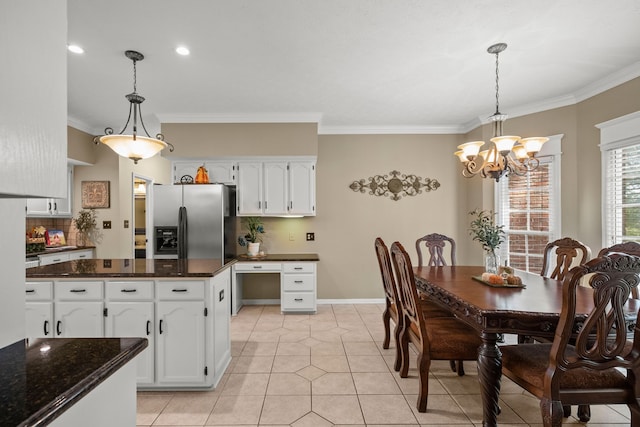 kitchen featuring light tile patterned flooring, white cabinetry, stainless steel refrigerator with ice dispenser, decorative light fixtures, and crown molding