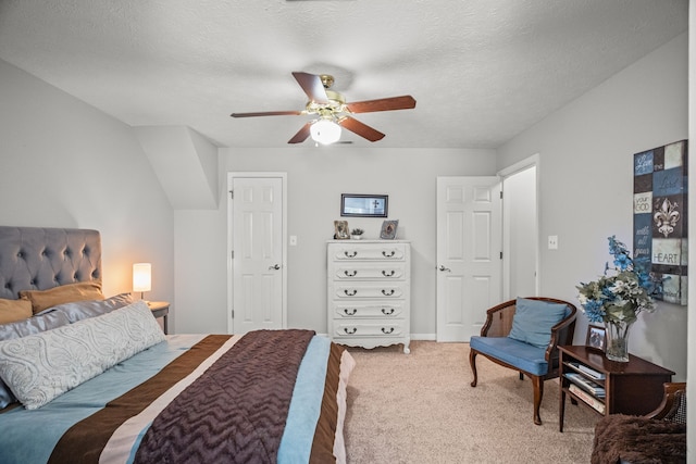 carpeted bedroom featuring ceiling fan and a textured ceiling