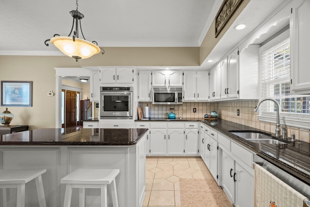 kitchen with dark stone counters, sink, decorative light fixtures, light tile patterned flooring, and stainless steel appliances