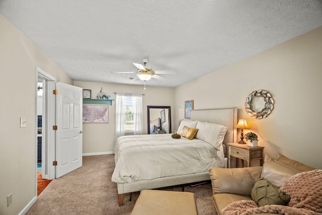 carpeted bedroom with ceiling fan, baseboards, and a textured ceiling