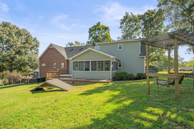 rear view of house with a lawn, fence, a sunroom, and a pergola