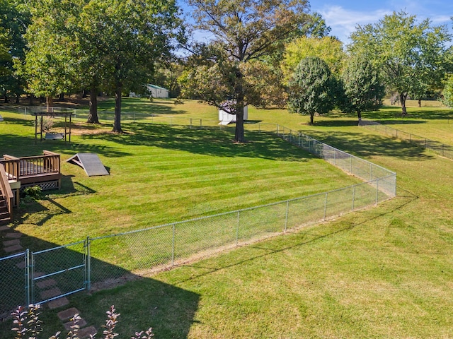 view of community featuring a yard, fence, and a wooden deck