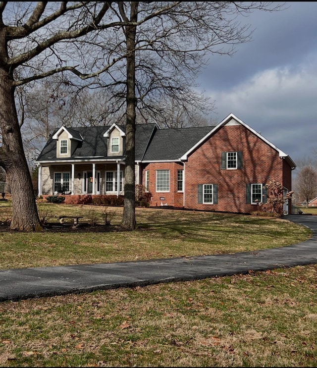 cape cod house with a front yard