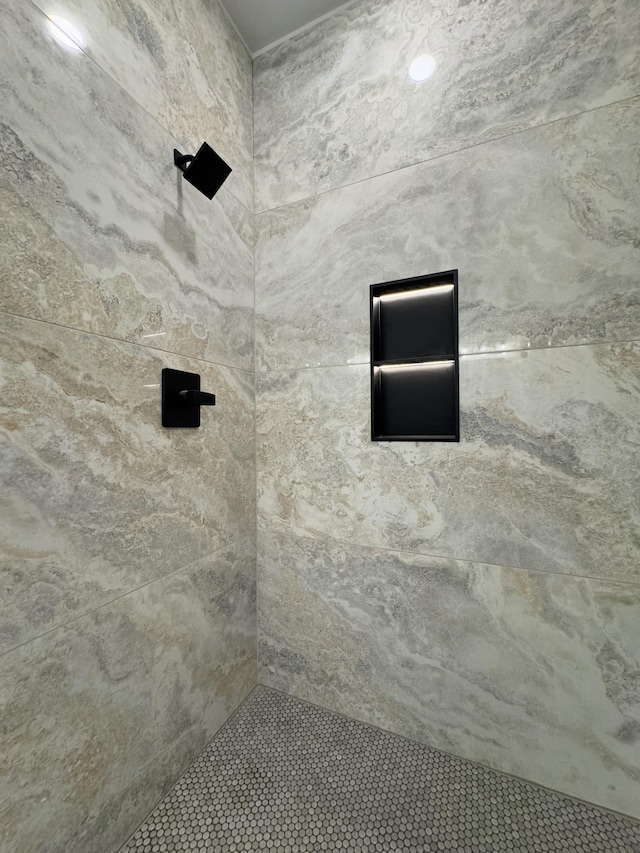 interior details featuring a tile shower