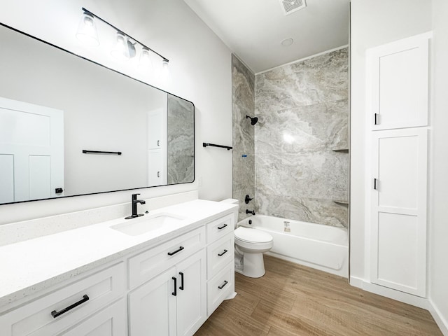 full bath featuring toilet, wood finished floors, visible vents, vanity, and shower / washtub combination