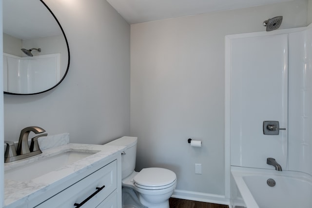 full bathroom with toilet, vanity, wood-type flooring, and washtub / shower combination