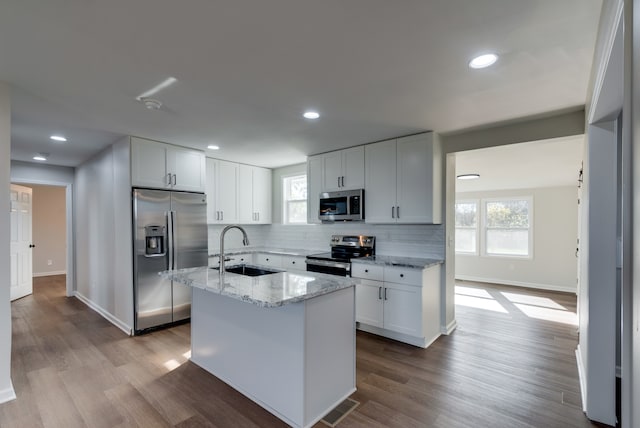 kitchen with a wealth of natural light, sink, white cabinets, and appliances with stainless steel finishes