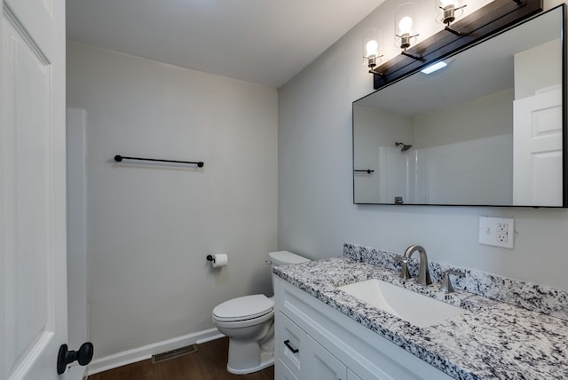 bathroom featuring vanity, toilet, wood-type flooring, and a shower