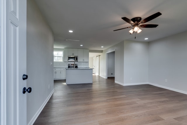 unfurnished living room featuring light wood-type flooring and ceiling fan