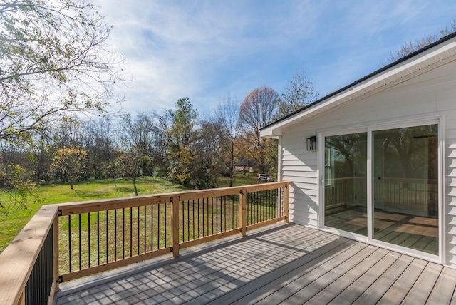 wooden deck featuring a lawn