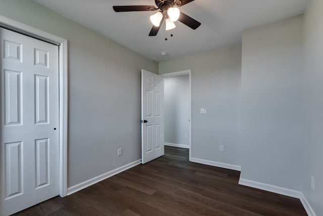 unfurnished bedroom featuring ceiling fan and dark hardwood / wood-style flooring