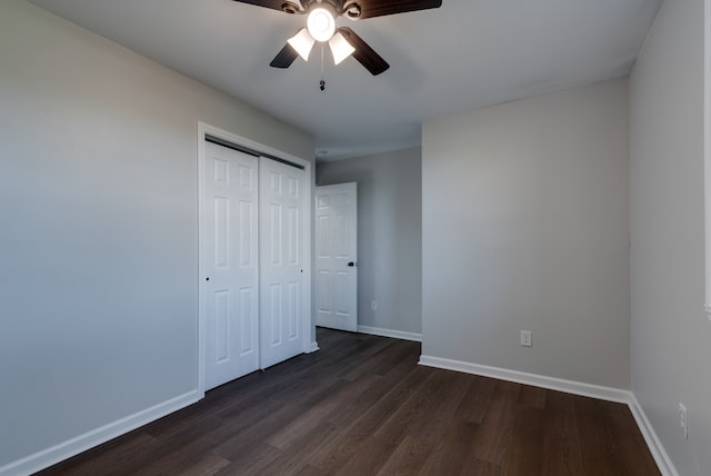 unfurnished bedroom featuring a closet, dark hardwood / wood-style floors, and ceiling fan