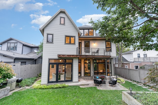 rear view of house featuring a yard, a balcony, a patio, and an outdoor hangout area