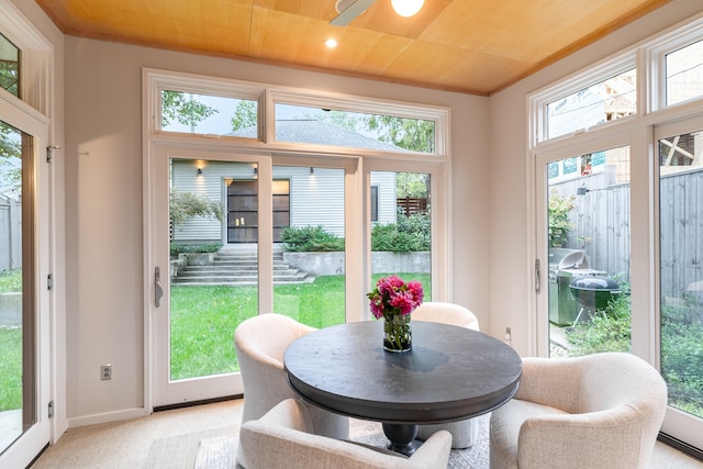 sunroom with ceiling fan, plenty of natural light, and wood ceiling