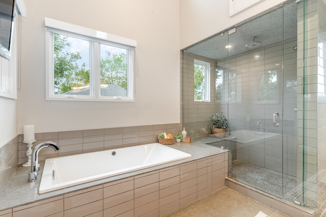 bathroom featuring separate shower and tub, a wealth of natural light, and tile patterned flooring