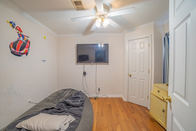 bedroom featuring a textured ceiling, light hardwood / wood-style floors, ceiling fan, and crown molding