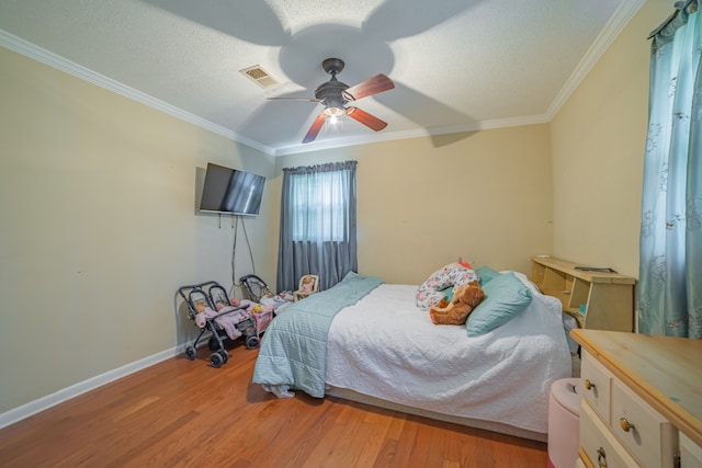 bedroom with light wood-type flooring, ceiling fan, and crown molding