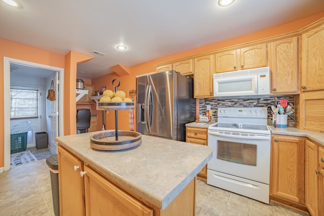 kitchen with white appliances, a center island, and backsplash