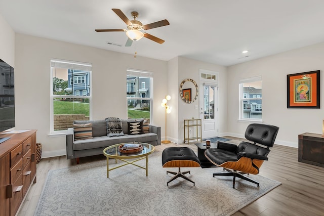 living room with light hardwood / wood-style floors and ceiling fan