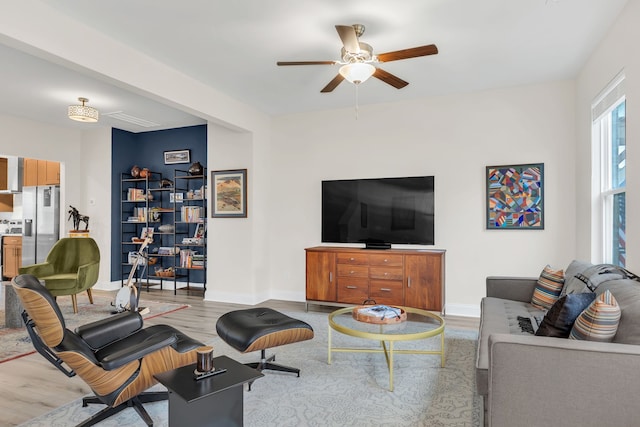 living room with light hardwood / wood-style floors and ceiling fan