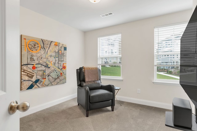 living area featuring light carpet