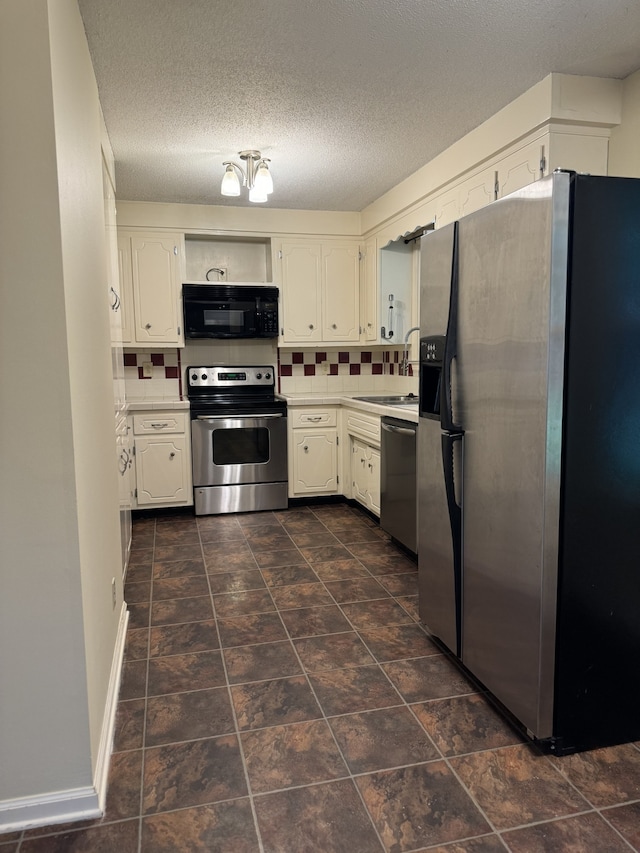 kitchen with tasteful backsplash, sink, white cabinets, and appliances with stainless steel finishes