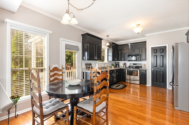 dining area featuring a chandelier, a wealth of natural light, crown molding, and light hardwood / wood-style floors