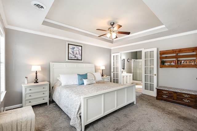 carpeted bedroom featuring a tray ceiling, connected bathroom, ceiling fan, and french doors