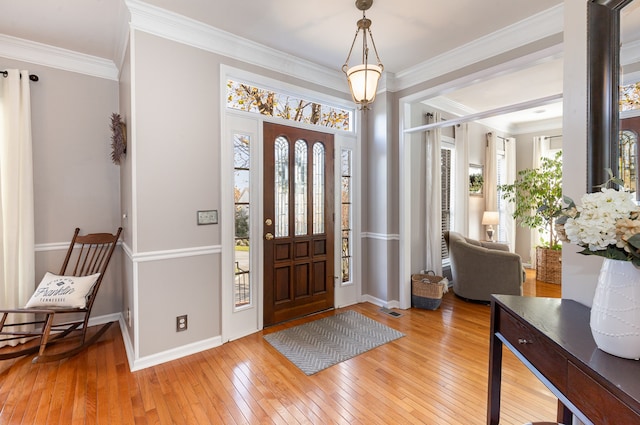 entryway with ornamental molding and light wood-type flooring