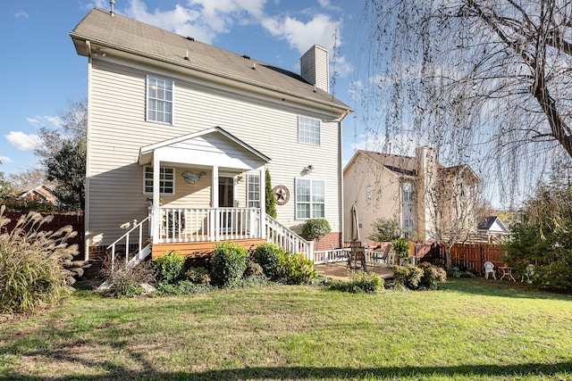 rear view of house with a lawn and a patio