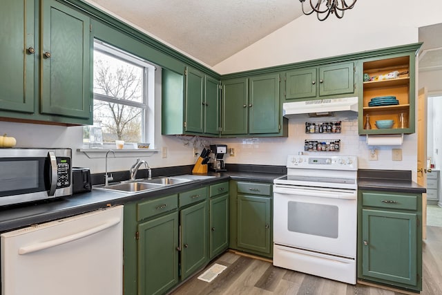 kitchen with green cabinetry, white appliances, sink, and vaulted ceiling