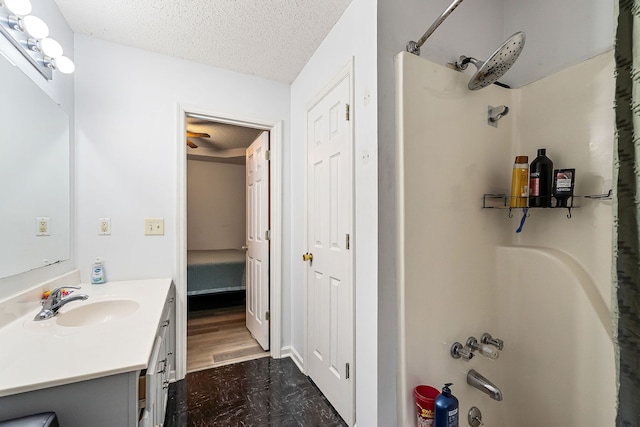 bathroom with hardwood / wood-style floors, vanity, a textured ceiling, and tub / shower combination