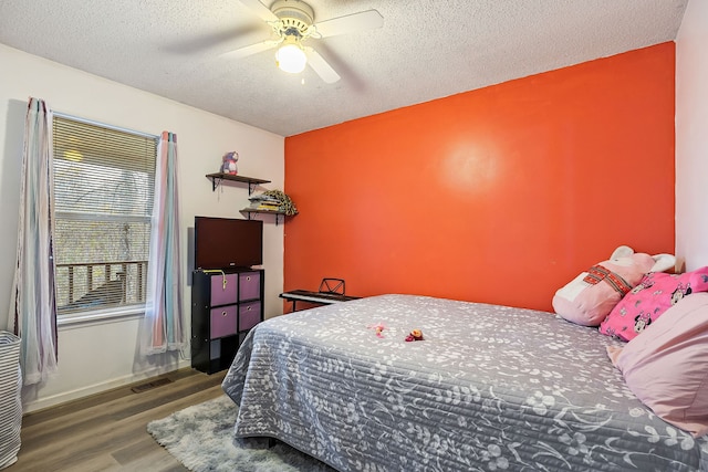 bedroom with ceiling fan, dark hardwood / wood-style flooring, and a textured ceiling