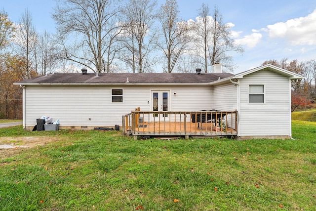 back of property with a lawn, french doors, and a deck