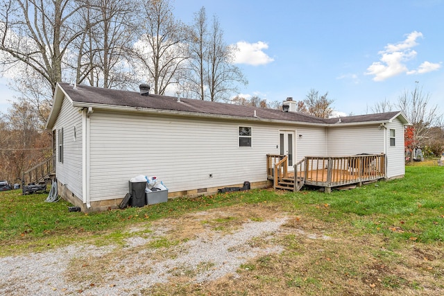 rear view of house with a wooden deck and a yard