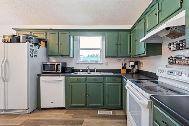 kitchen with light hardwood / wood-style floors, green cabinets, white appliances, and sink