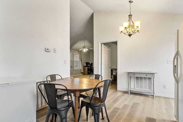 dining area featuring a textured ceiling, light hardwood / wood-style flooring, high vaulted ceiling, and ceiling fan with notable chandelier