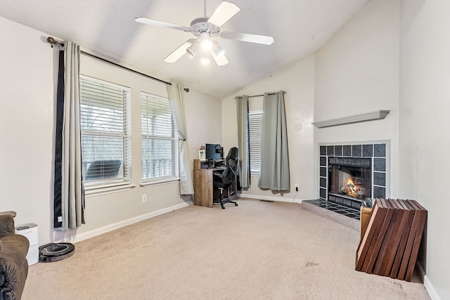 home office featuring ceiling fan, carpet floors, a textured ceiling, vaulted ceiling, and a tiled fireplace