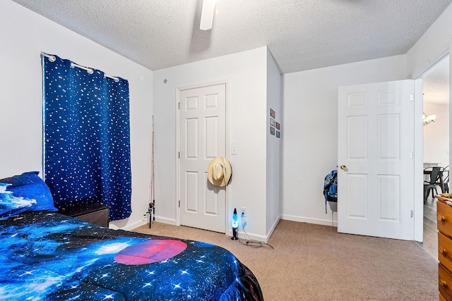 carpeted bedroom featuring a textured ceiling and ceiling fan