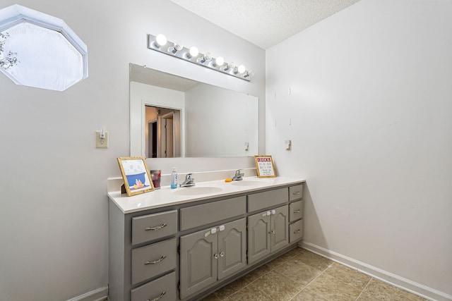 bathroom with vanity, a textured ceiling, and tile patterned flooring