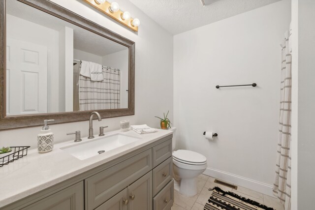 bathroom with vanity, a textured ceiling, tile patterned floors, and toilet