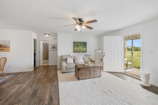 living room with a textured ceiling, light hardwood / wood-style flooring, and ceiling fan