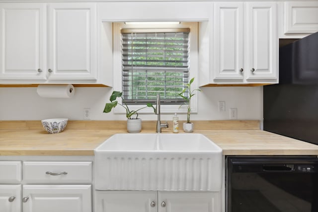 kitchen featuring black appliances, wood counters, white cabinetry, and sink