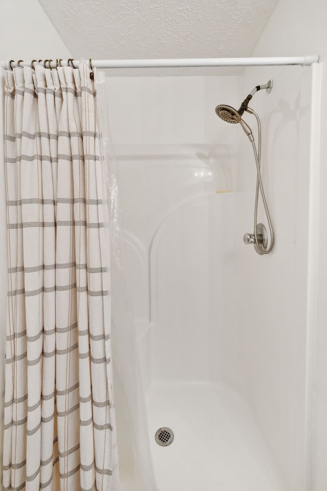 bathroom featuring curtained shower and a textured ceiling