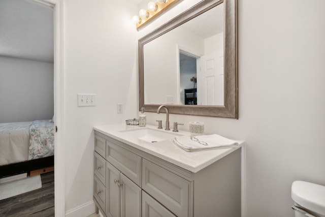 bathroom with vanity, wood-type flooring, and toilet