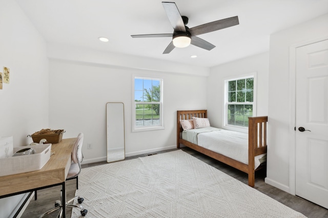 bedroom featuring hardwood / wood-style floors, multiple windows, and ceiling fan