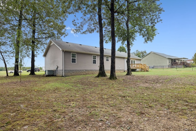 rear view of house featuring a yard and a deck